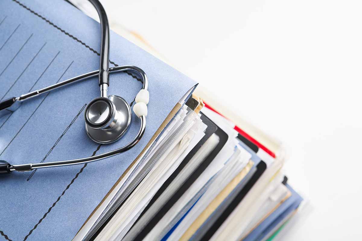 a stack file folders with a stethoscope on top