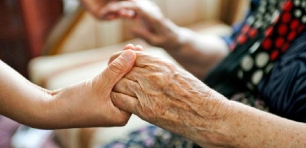 A younger persons hands joined with an elderly persons hands
