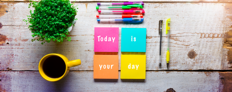 Wooden desktop with sticky notes that read "Today is your day"