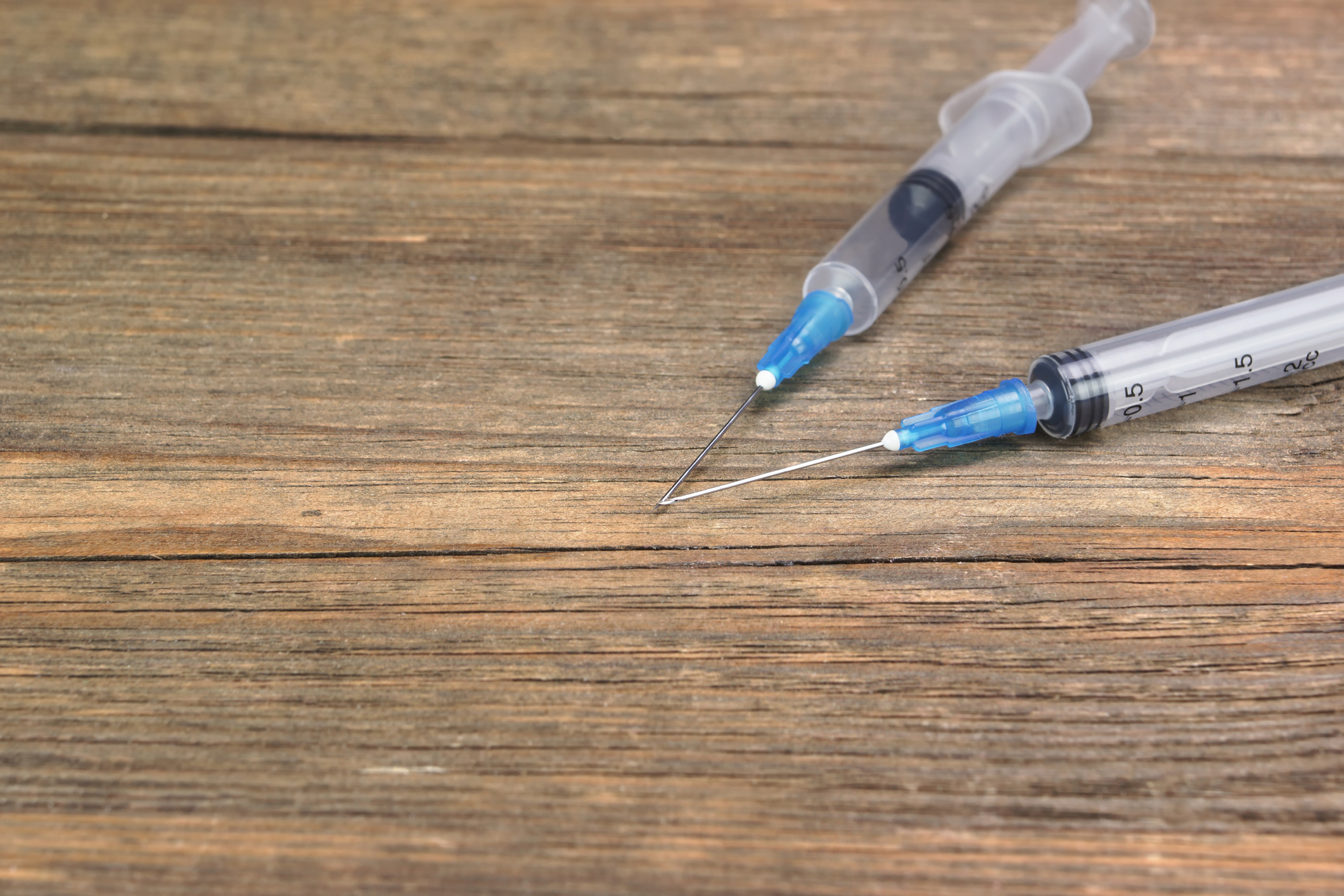 Two Small Empty Disposable Syringe On Wood Background