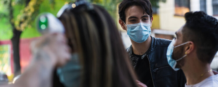 Latin American man hanging out with friends wearing masks during the COVID-10 pandemic.