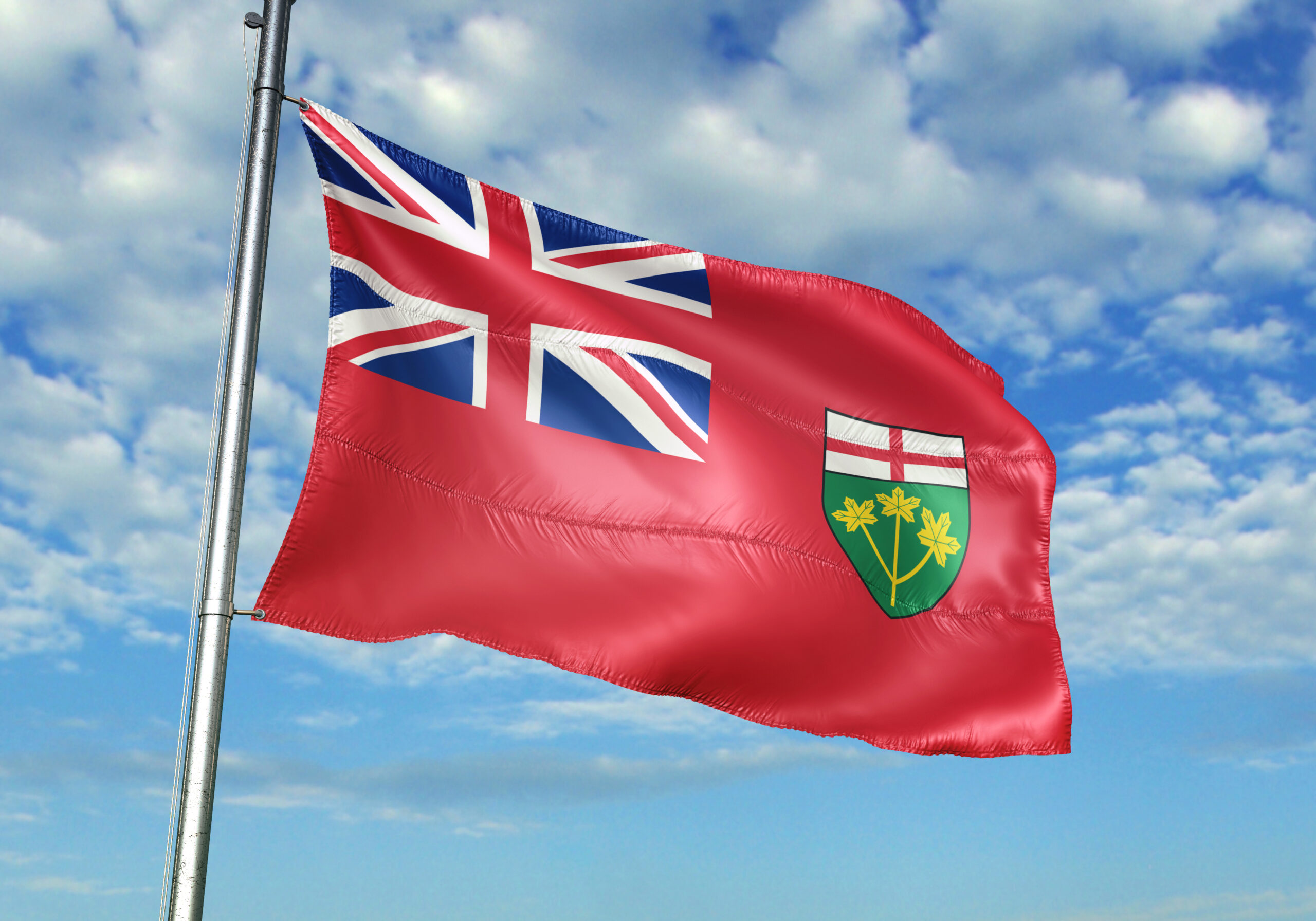 Ontario flag on a flagpole against a blue sky