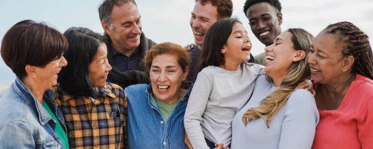 Crowd of multi generational people hugging each other outdoor - Multiracial friends having fun together